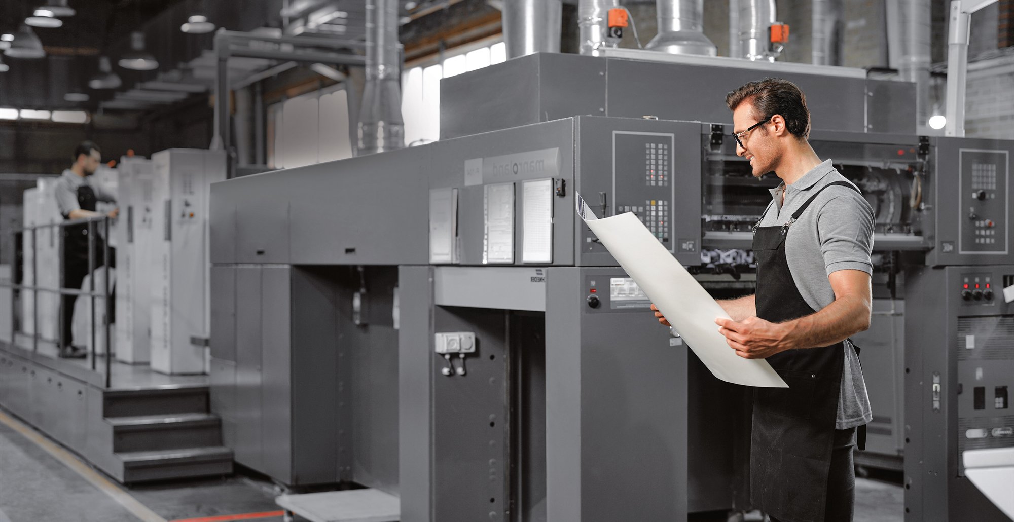 Offset printing specialist inspecting a printed sheet